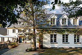 Außenansicht der Diepeschrather Mühle mit Garten und historischer Architektur